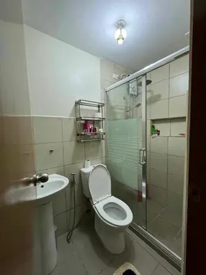 a bathroom with a toilet and a shower and a sink at bendetto residences in Manila