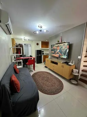 a living room with a couch and a flat screen tv at bendetto residences in Manila