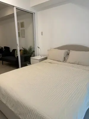 a bedroom with a large white bed in a room at Dwell at Azure Urban Resort Residences Bahamas Tower in Manila