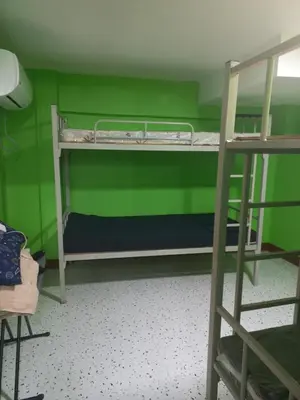 a room with two bunk beds with green walls at Joshua Transient in Manila