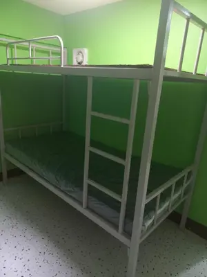 two bunk beds in a room with green walls at Joshua Transient in Manila