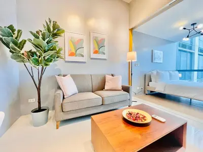 a living room with a couch and a table at One Uptown Residence BGC in Manila