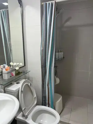 a bathroom with a toilet and a shower and a sink at Affordable Azure Staycation in Manila