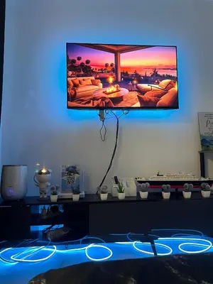 a room with a tv on the wall with blue lights at Affordable Azure Staycation in Manila