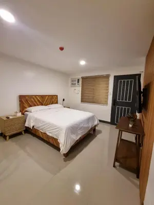 a bedroom with a large bed and a table at Flat 35, Unit 1E in Manila