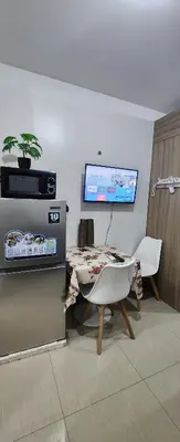 a living room with a table and a table and a television at STAYCATION near MOA in Manila