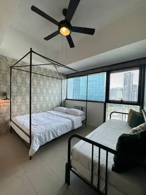 a bedroom with two beds and a ceiling fan at 1br wNetflix Disneyplus and pool across SM Megamall Ortigas CBD in Manila
