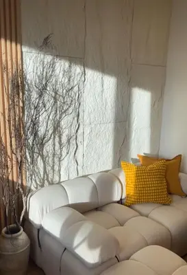 a white couch with yellow pillows in a room at Sarannya Home BGC in Manila