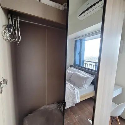 a bedroom with a bed and a mirror at Air Residences - Panoramic City View near Airport - 4734 in Manila