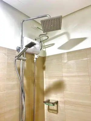 a shower with a shower head in a bathroom at Jen staycation in Manila