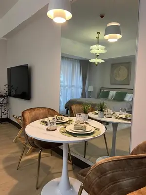 a living room with two tables and a couch at Minimalist and cozy place with balcony in Manila