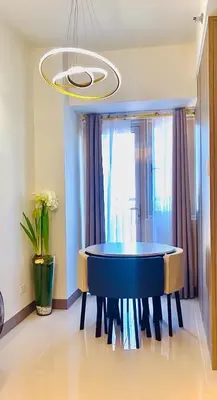a dining room with a blue table and a chandelier at Cosy Deluxe Flat with Balcony near MOA in Manila