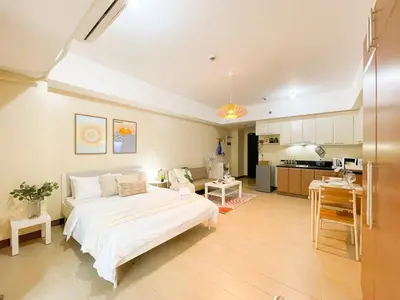 a bedroom with a large bed and a kitchen at Elegant Condo at Venice Grand Canal BGC #vlrtc27e in Manila