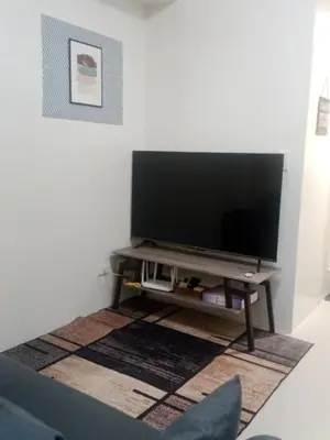a flat screen tv sitting on a stand in a living room at Jazz stacation in Manila