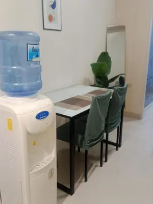 a table and chairs with a water cooler next to it at Jazz stacation in Manila