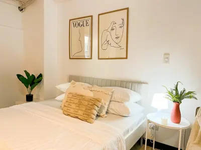 a bedroom with a white bed with two pictures on the wall at BGC Luxury, Venice Grand Canal Mall #vlrtc27c in Manila