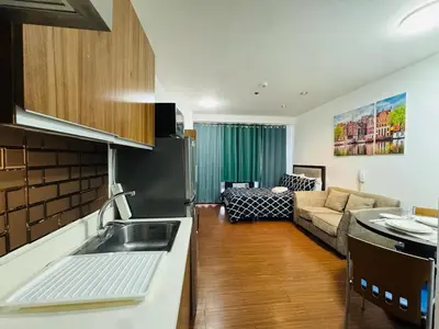 a kitchen and a living room with a couch at Makati City Studio with Balcony Near Bgc And Airport in Manila