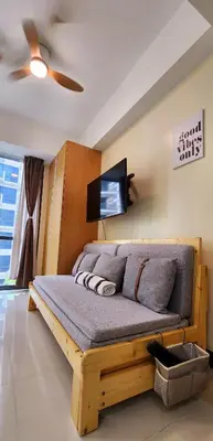 a bedroom with a wooden bed with a flat screen tv at xxxCozy Family Retreat 8 mins walk from Venice Grand Canal Mall BGC fits 5 pax in Manila