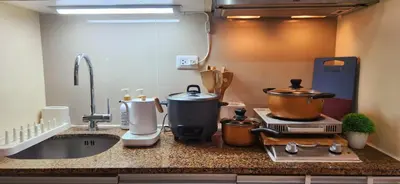 a kitchen counter with pots and pans on a stove at xxxCozy Family Retreat 8 mins walk from Venice Grand Canal Mall BGC fits 5 pax in Manila
