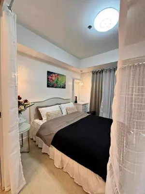 a bedroom with a large bed with a black blanket at A2Z Staycation at Azure Urban Residences in Manila