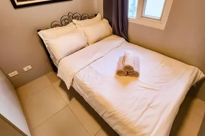 a bed with a pair of slippers on it at Homey 2br Apt 5 in Makati City in Manila