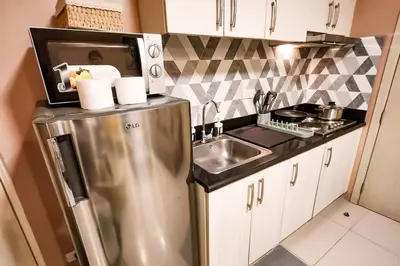 a kitchen with a stainless steel refrigerator and a sink at Homey 2br Apt 4 in Makati City in Manila