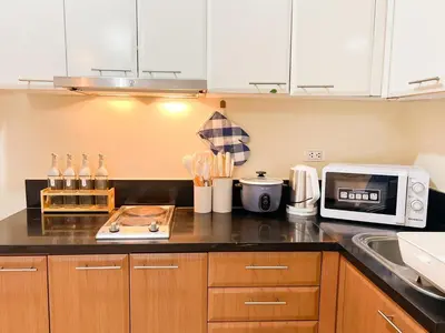 a kitchen with a counter top with a microwave at Stylish Condo, Venice BGC, Pool, WiFi #vlrtc29e in Manila