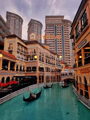 a group of gondolas in a river in a city at Stylish Condo, Venice BGC, Pool, WiFi #vlrtc29e in Manila