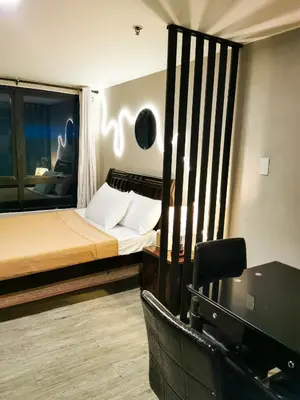 a hotel room with a bed and a desk and a desk at ADB Avenue Tower Staycation in Manila