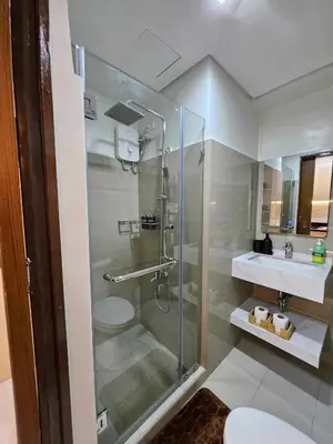 a bathroom with a shower and a toilet and a sink at Lourdes' Place, Shore 2-Tower 1, 2 Beds, Pasay near Mall of Asia in Manila
