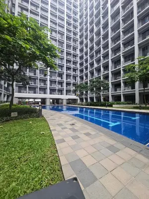 a large building with a swimming pool in front of it at Lourdes' Place, Shore 2-Tower 1, 2 Beds, Pasay near Mall of Asia in Manila