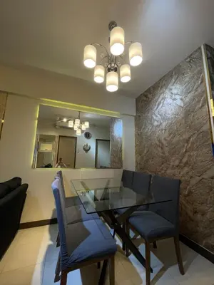 a dining room with a glass table and chairs at Mirea Residences Pasig- Two Bedroom Condo Unit with Balcony 70sqm in Manila