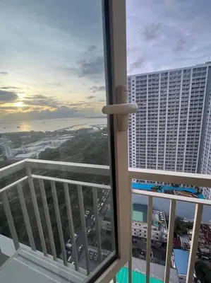 a balcony with a view of a large building at Coast Residence Sea View Balcony Netflix WiFi Near MOA 3146 in Manila