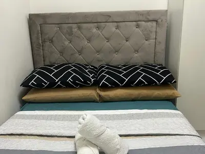 a bed with black and white pillows and white socks at 2BR Coast Residences in Manila