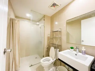 a bathroom with a toilet and a sink and a shower at Cozy Condo in Venice BGC with balcony #vlrtc28C in Manila