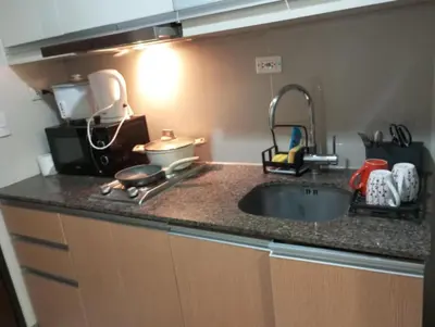 a kitchen with a sink and a counter top at One Uptown Residence in Manila