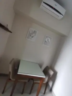 a table and two chairs in a room at One Uptown Residence in Manila