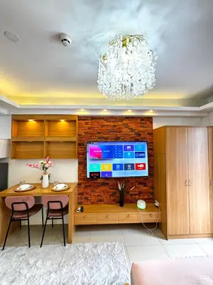 a living room with a television on a brick wall at European Inspired Shore 2 Residences in Manila