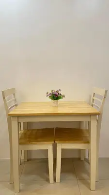 a wooden table with two chairs and a vase with flowers at Cozy Condo Beacon Tower Makati in Manila