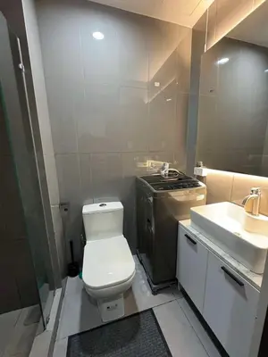 a bathroom with a white toilet and a sink at Heathers Crib In Ayala Makati City in Manila