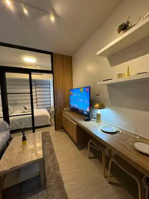 a room with a desk with a television and a bed at Heathers Crib In Ayala Makati City in Manila