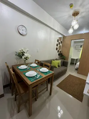 a living room with a table and a couch at Bloom Residences by Casa Stellar in Manila