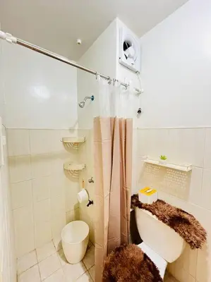a white bathroom with a toilet and a shower at Fablo Getaway beside EK in Santa Rosa