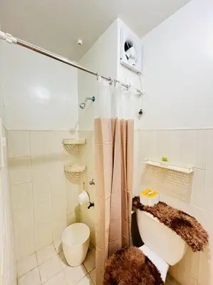 a white bathroom with a toilet and a shower at Fablo Getaway beside EK in Santa Rosa