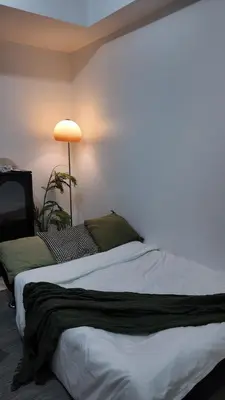 a hotel room with two beds and a lamp at Relaxing Suite Across NAIA Terminal 3 in Manila
