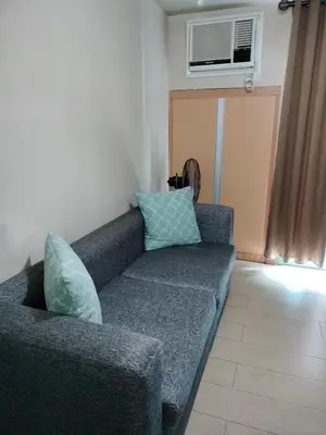 a couch with pillows sitting in a living room at ROOM NEAR AIRPORT BY RQUi in Manila