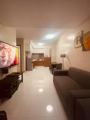 a living room with a couch and a flat screen tv at 2BR-T31807 Sunshine100 Pool Billiard 70 inches TV Karaoke in Manila