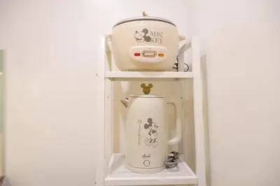 a white coffee maker sitting on a shelf at 1BR Mickey Mouse Theme BGC Forbeswood Parklane in Manila