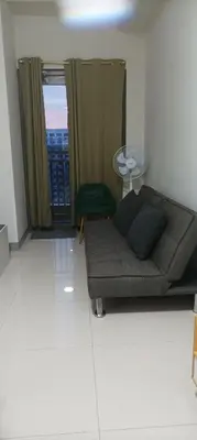 a living room with a couch and a glass table at Charlie's Penthouse in Mall of Asia Complex in Manila