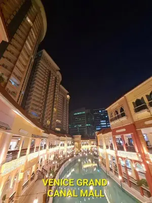 a city street at night with tall buildings at Prime Condo Living Near Venice Canal #msert26k in Manila
